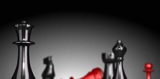 Black and red chess pieces on a board.