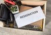 Envelope labeled RESIGNATION atop office supplies in box