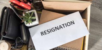 Envelope labeled RESIGNATION atop office supplies in box