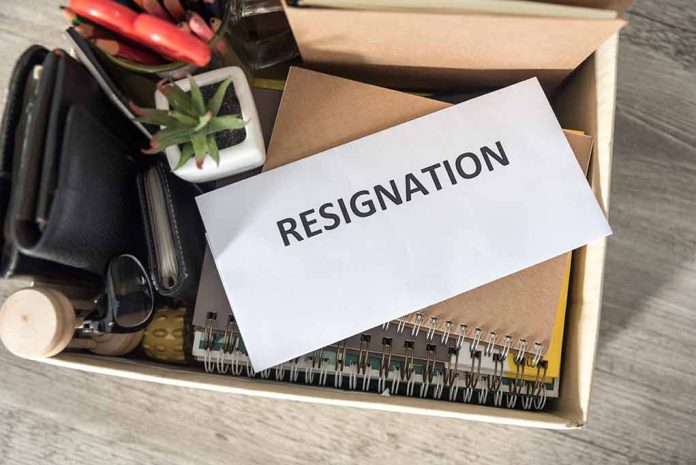 Envelope labeled RESIGNATION atop office supplies in box