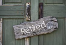 Wooden "Retired" sign on an old green door.