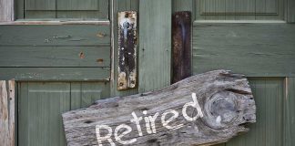 Wooden "Retired" sign on an old green door.