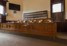 Empty courtroom with a jury box and bookshelves