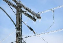 Icicles hanging from power lines and pole.