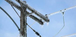 Icicles hanging from power lines and pole.