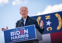 Man speaking at podium during outdoor event