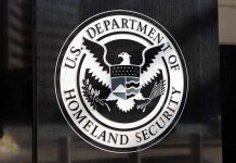 U.S. Department of Homeland Security emblem on wall.