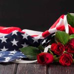 American flag with red roses on dark background