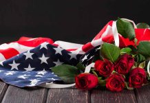 American flag with red roses on dark background