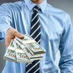 Person handing over a stack of money.