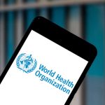 Smartphone displaying World Health Organization logo background