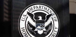 U.S. Department of Homeland Security emblem on wall.