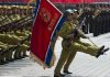 Soldiers marching with rifles and a red flag