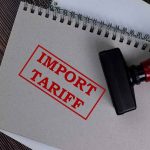 Notebook with "Import Tariff" stamp and rubber stamper.