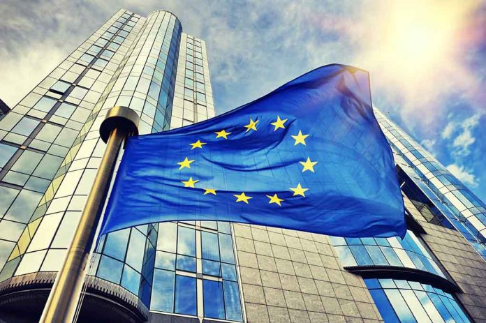 European Union flag waving in front of skyscraper.