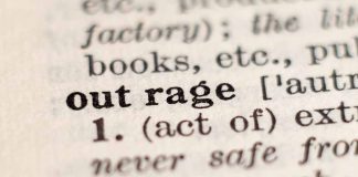 Close-up of the word outrage in a dictionary