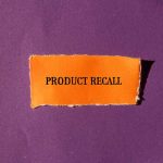 "Product Recall" text on orange paper against purple background.