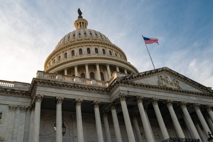 2443980471 featured image US Capitol building with American flag flying above