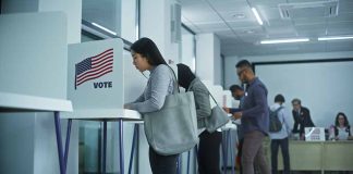 People voting in booths at a polling station.