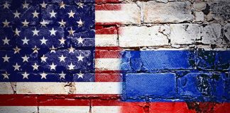 United States and Russian flags painted on brick wall