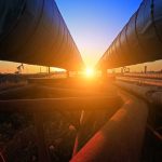 Sunset between two large industrial pipelines outdoors