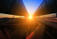 Sunset between two large industrial pipelines outdoors