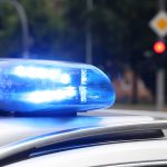 Blue police siren light flashing on vehicle roof