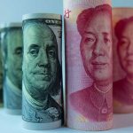 Rolled US dollar and Chinese yuan banknotes.
