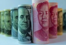 Rolled US dollar and Chinese yuan banknotes.