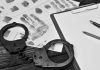 Handcuffsfingerprint sheets and clipboard on a desk