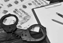 Handcuffsfingerprint sheets and clipboard on a desk