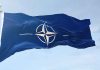 NATO flag waving against blue sky