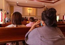 People sitting in church pews during service