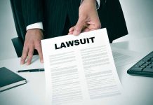 Person holding a document titled LAWSUIT in office
