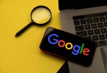 Magnifying glass laptop and smartphone displaying Google s logo