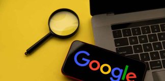 Magnifying glass laptop and smartphone displaying Google s logo