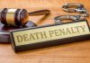 Gavel handcuffs and death penalty sign on table