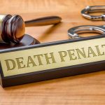 Gavel handcuffs and death penalty sign on table