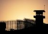 Sunset behind prison fence and guard tower