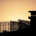Sunset behind prison fence and guard tower