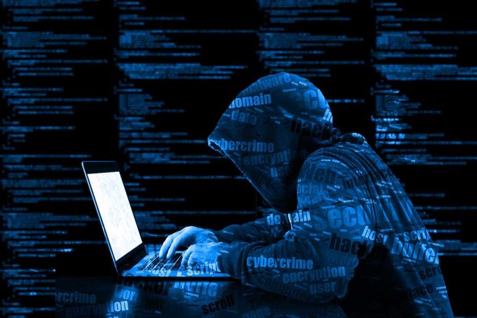 547592083 featured image Hooded figure using laptop with code background