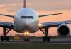 Airplane on runway during sunset.