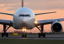 Airplane on runway during sunset.