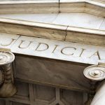 Marble columns with the word Judicial engraved above
