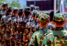 Soldiers in camouflage uniforms marching in formation outdoors