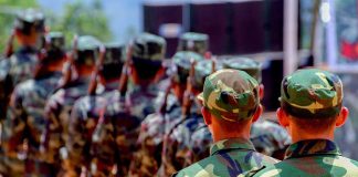 Soldiers in camouflage uniforms marching in formation outdoors