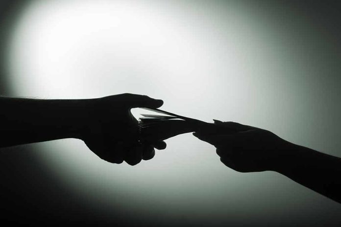 1028993377 featured image Silhouette of hands exchanging money in dim light