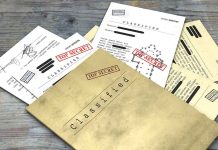Classified documents with Top Secret stamps on wooden surface