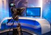 TV studio with camera and empty anchor desk