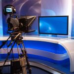 TV studio with camera and empty anchor desk